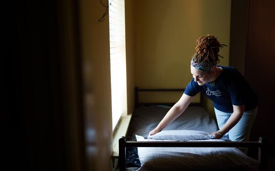 A case worker with Catholic Charities of Acadiana is pictured in a file photo preparing a bed at St. Joseph Shelter, an emergency shelter that cares for 87 individuals experiencing homelessness in and around Lafayette, Louisiana. (OSV News/Courtesy of Catholic Charities of Acadiana/Jason Cohen)